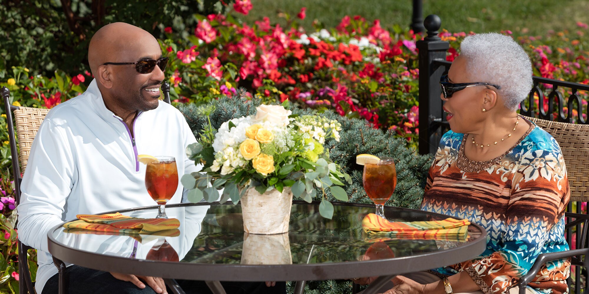 Couple enjoying iced tea on patio.