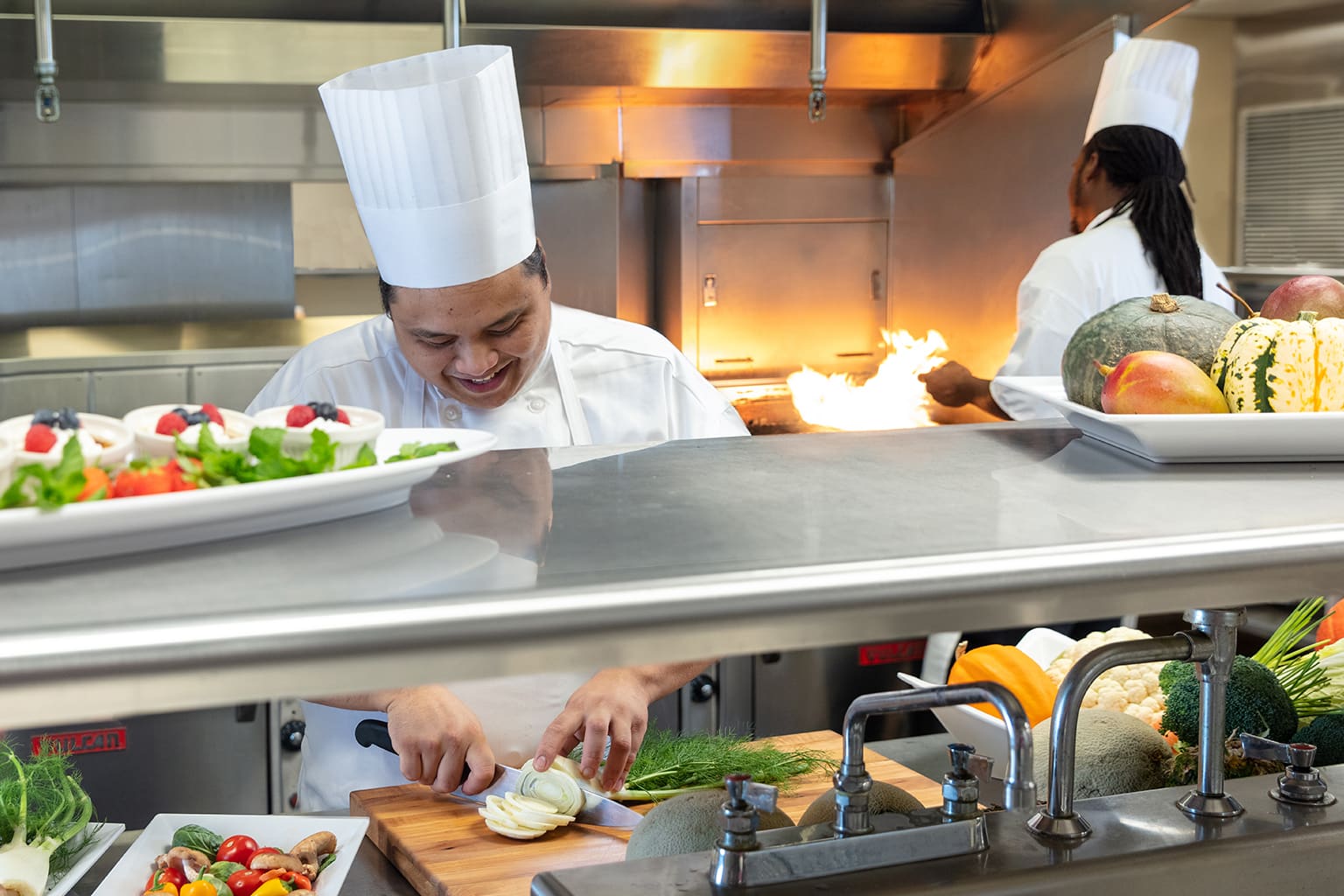 Executive Chef John Morales in kitchen preparing ingredients.