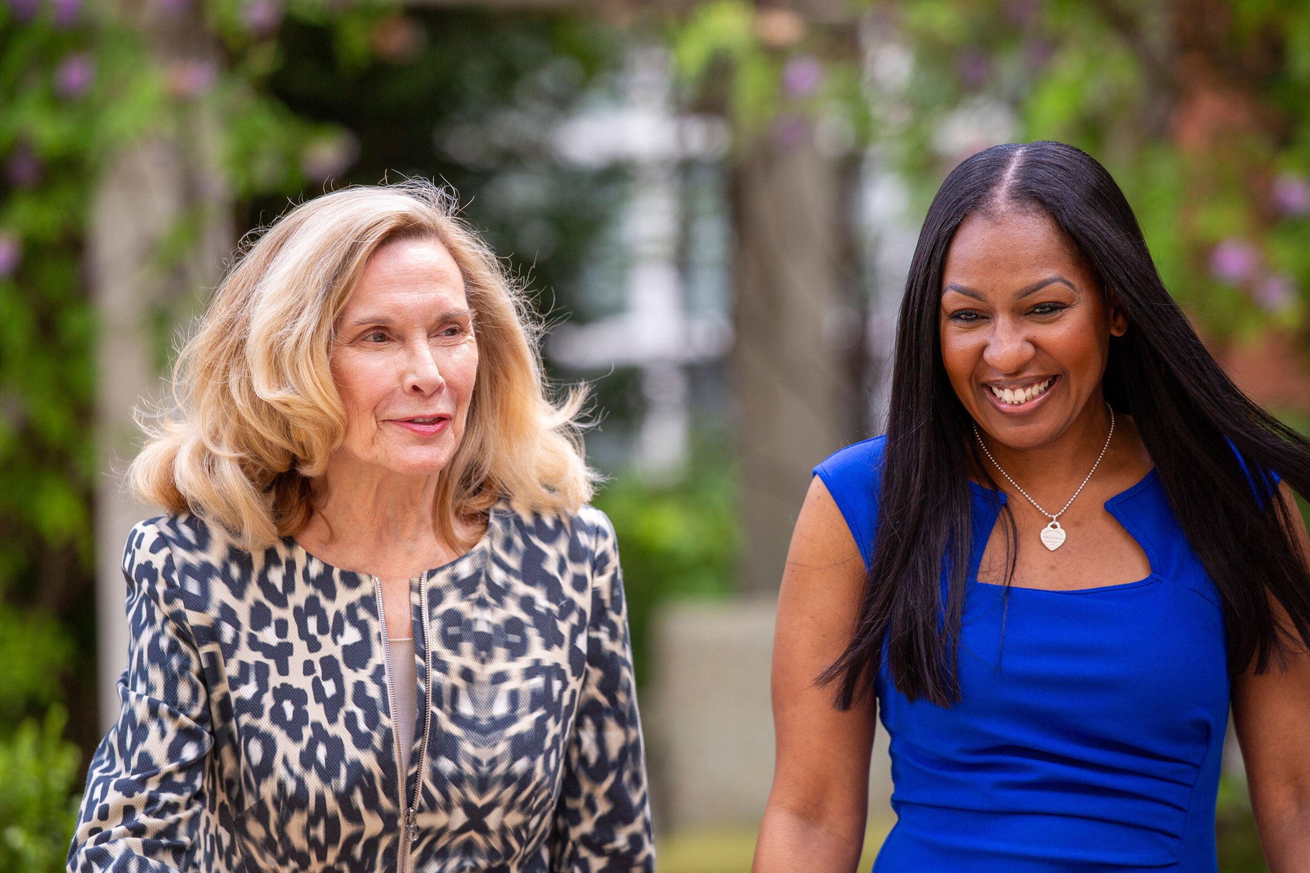 Two ladies walking outdoors in conversation.