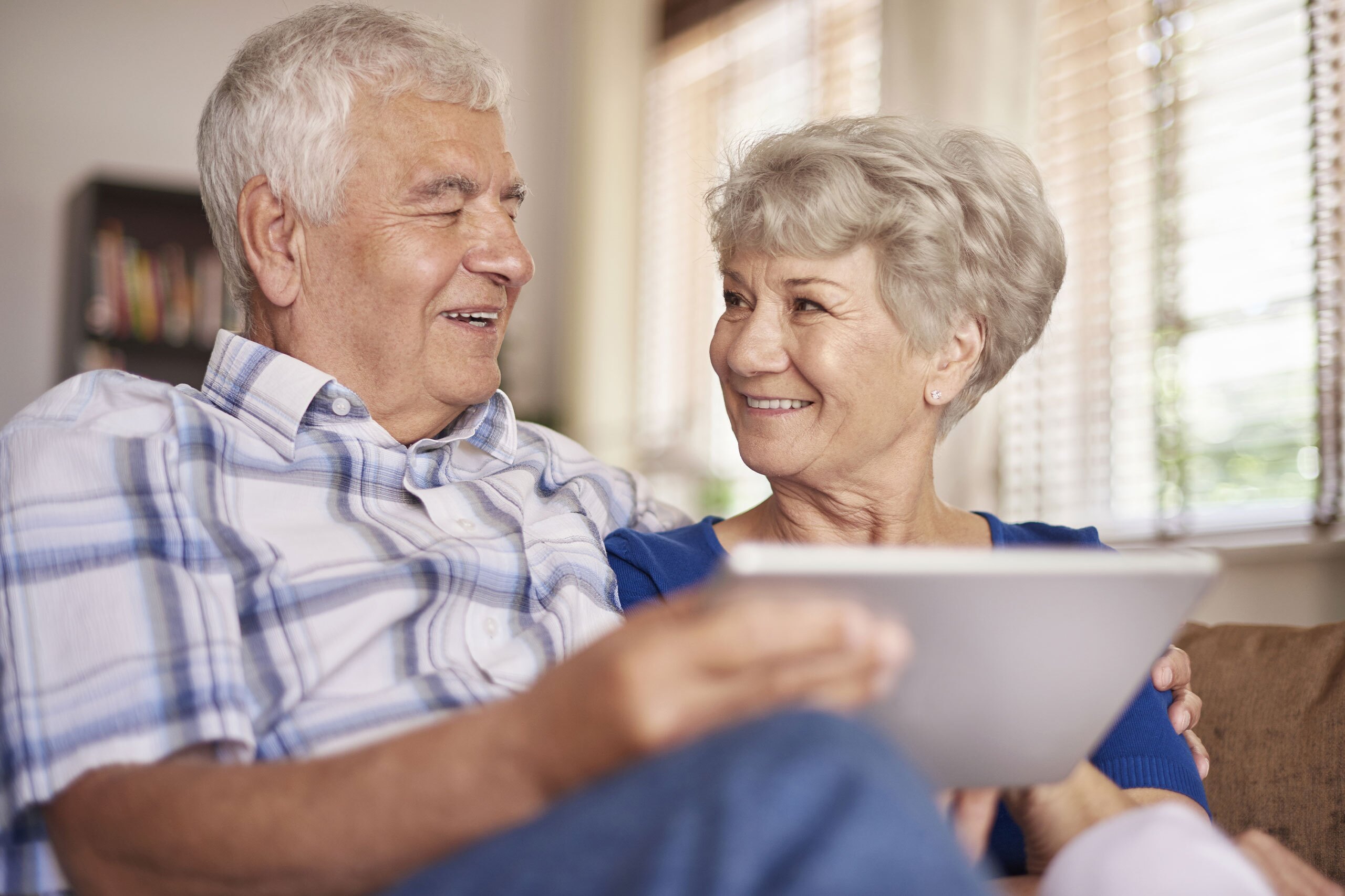 Elderly couple discussing something on an ipad.