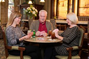 Trio playing cards and smiling