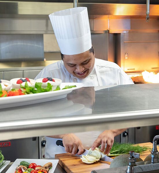A chef preparing food in the kitchen.