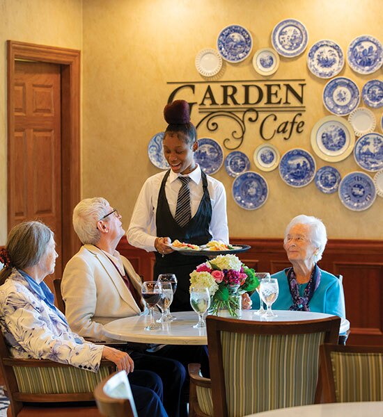 Residents and server in the Garden Cafe.