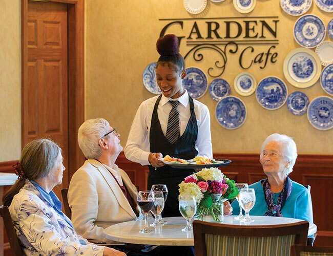 Residents and server in the Garden Cafe.
