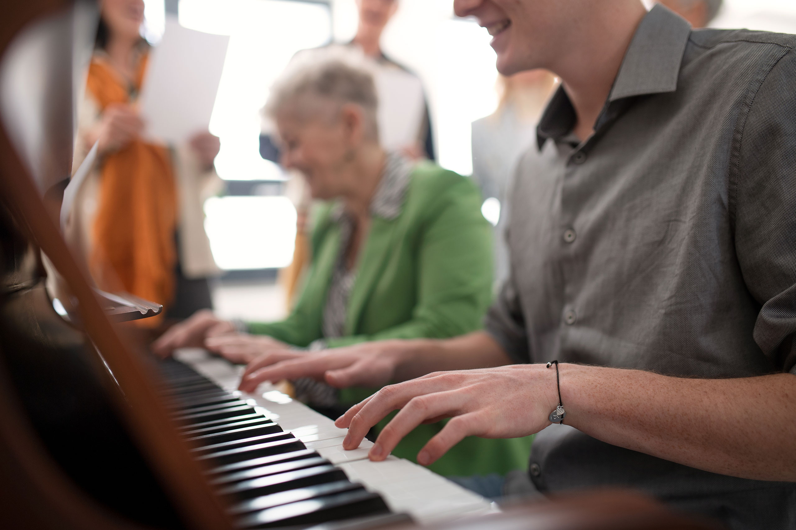 People playing and enjoying the piano.
