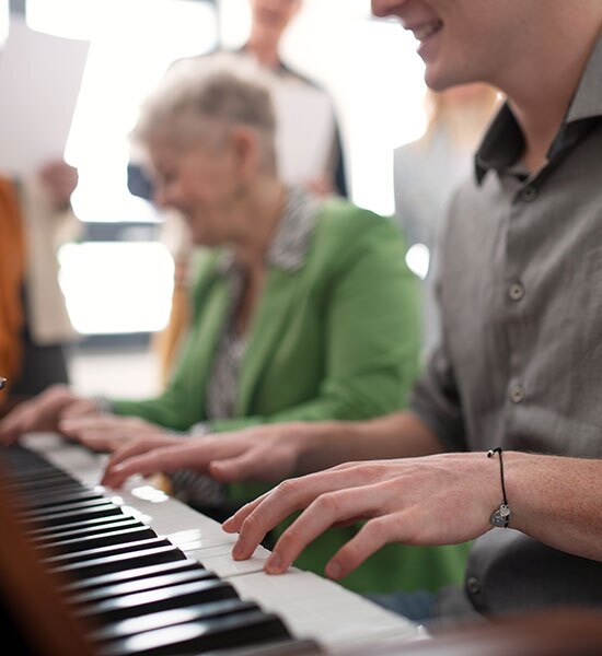 People playing and enjoying the piano.