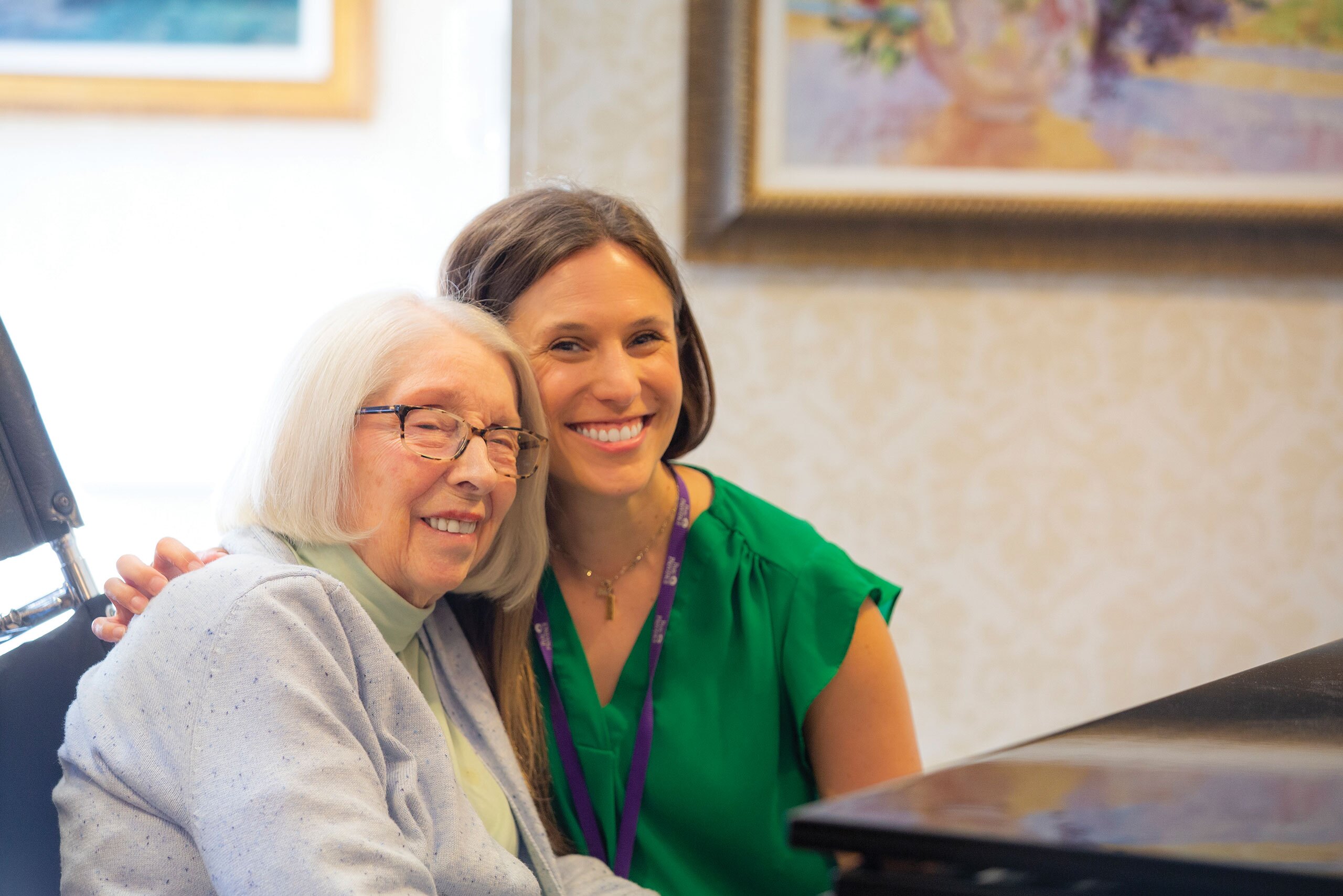 A resident and staff member seated and smiling.