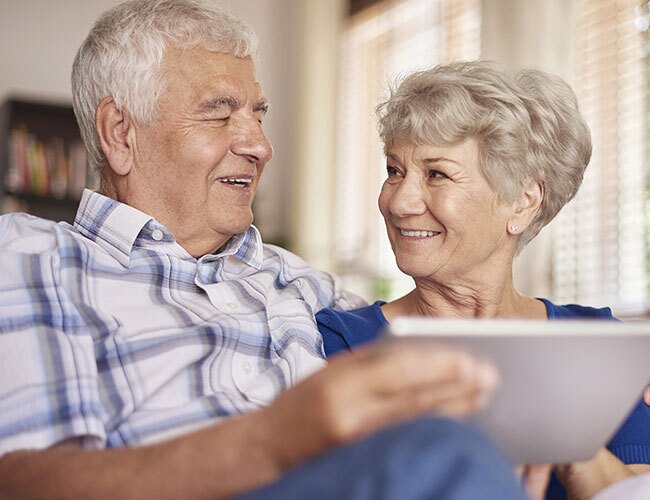 A couple smiling and looking at a document.