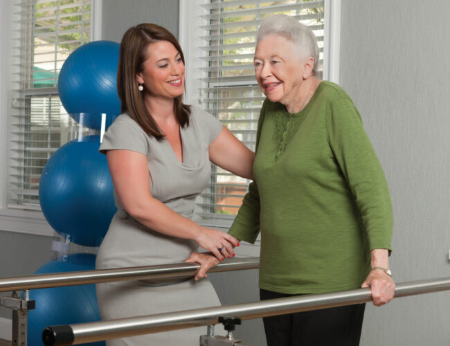 Therapist working on rehabilitation bar exercises with resident.