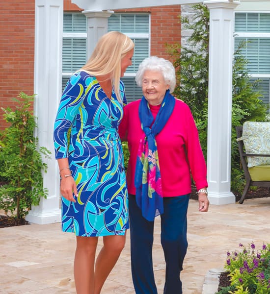 senior resident and McKnight employee walking.