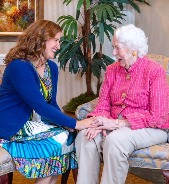 Senior resident seated and chatting with McKnight employee.